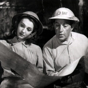 Les acteurs George Formby et Phyllis Calvert examinent une carte dans une scène du film britannique 